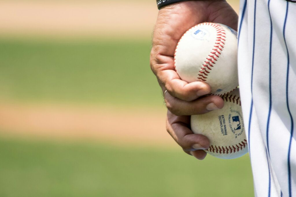 man holding 2 baseballs