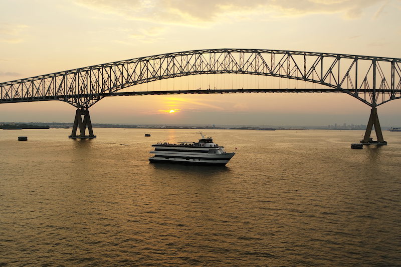 Schiff bei Sonnenuntergang Brücke im Hintergrund