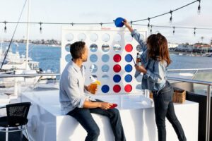 games man and woman playing connect four on boat