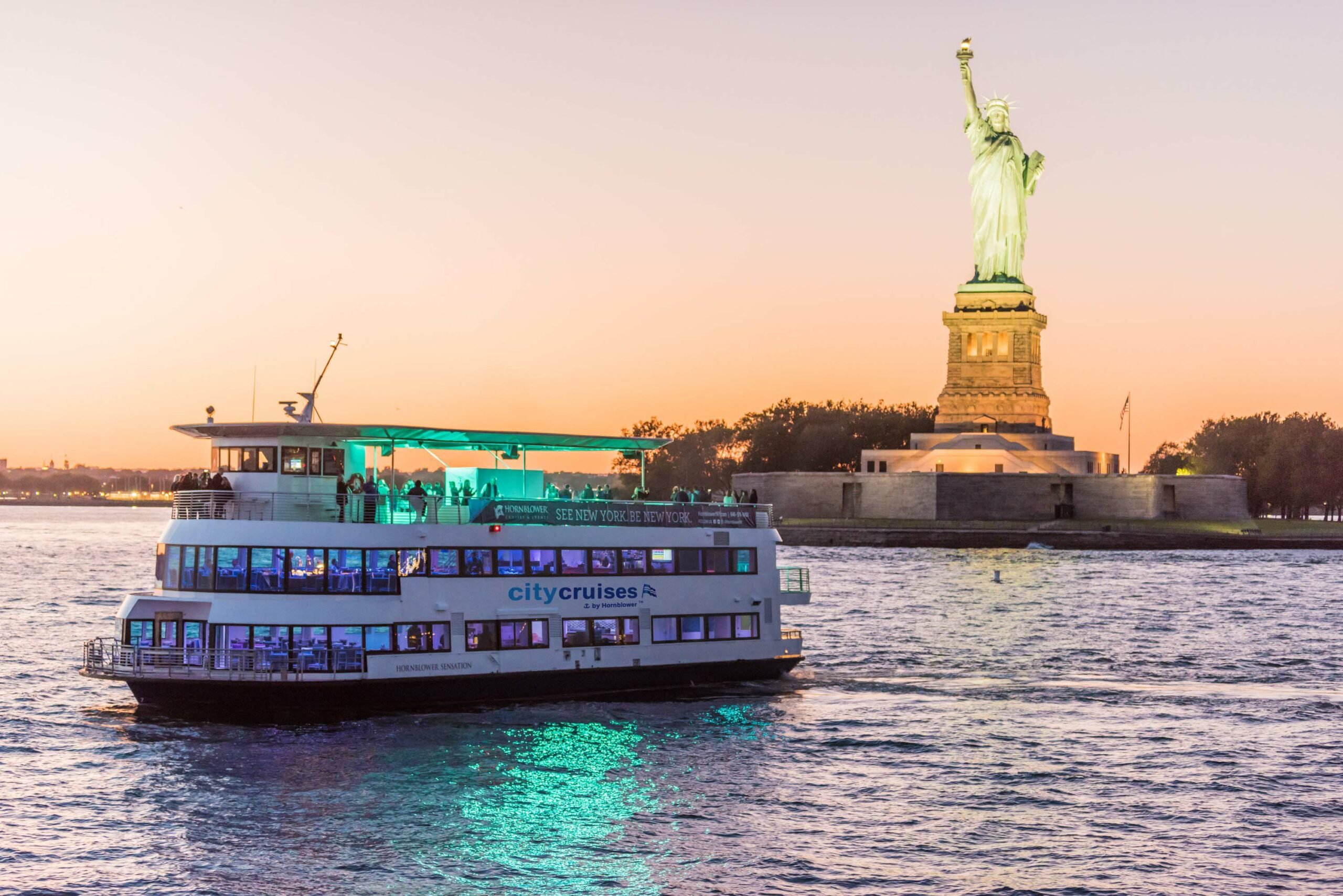 boat cruising around statue of liberty
