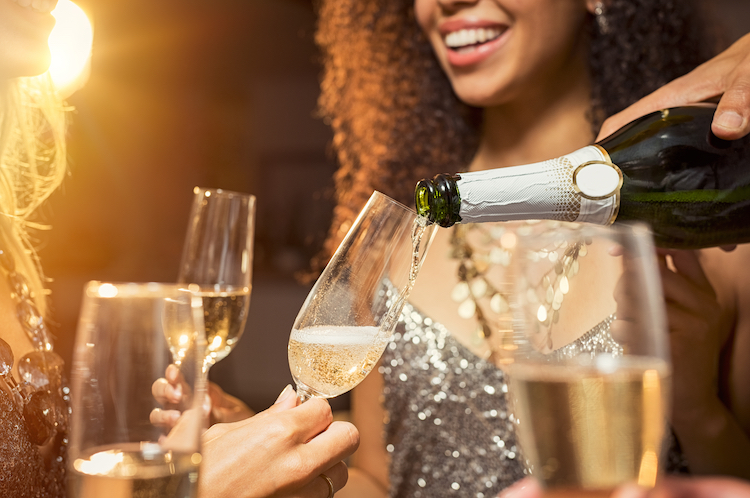 femme avec une coupe de champagne en train d'être versée.