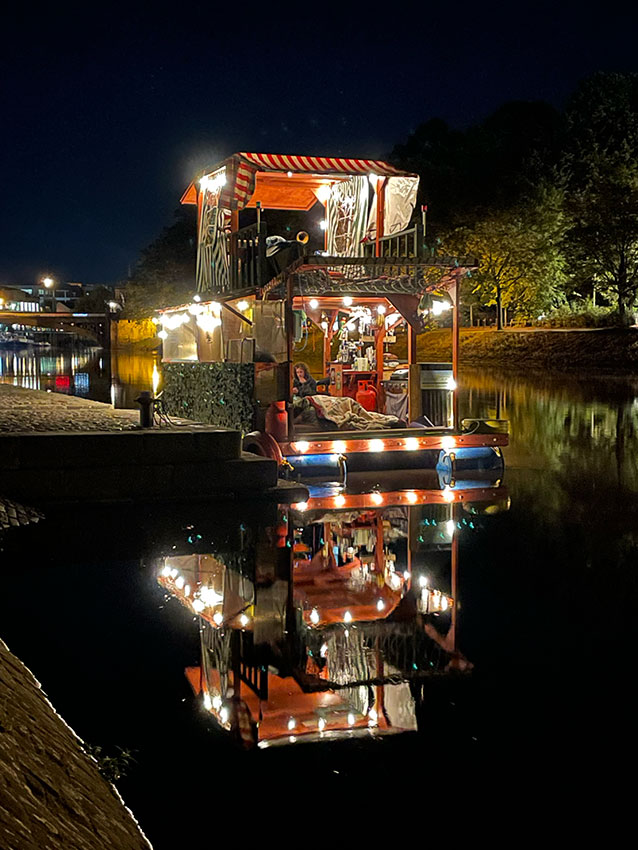 The Legends of the Ouse boat lit up in the night