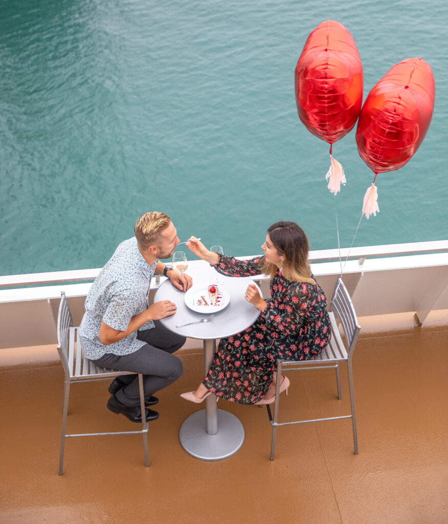couple on boat with heart balloons