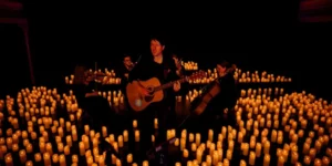 músico a tocar num palco à luz das velas