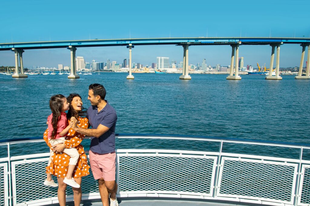 family on boat with cornado bridge in background san diego