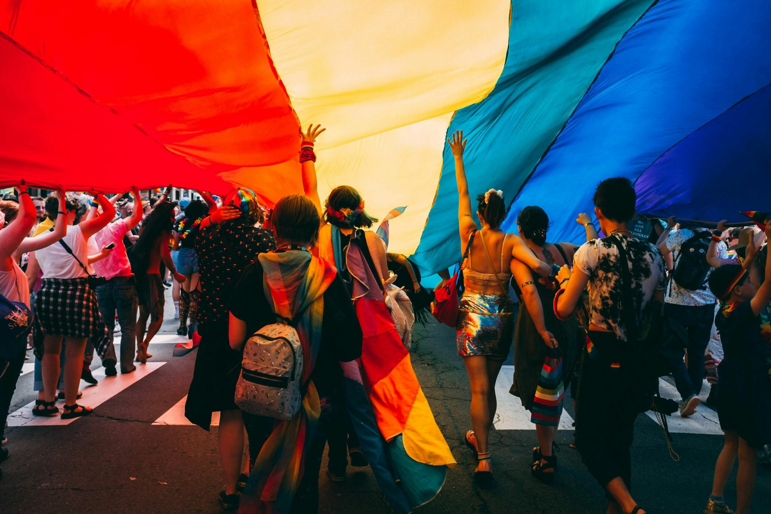 lgbtq+ group of people holding pride flag