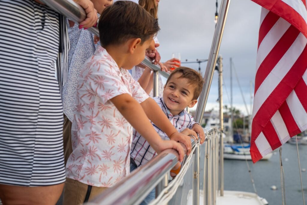 children on boat in newport beach with flag