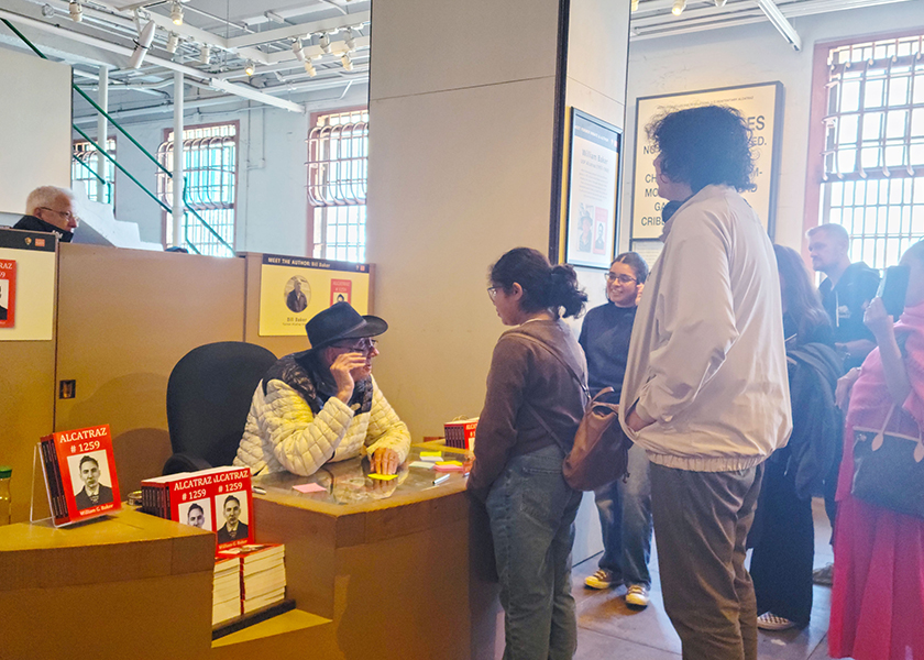 William Baker at desk speaking to people on Alcatraz