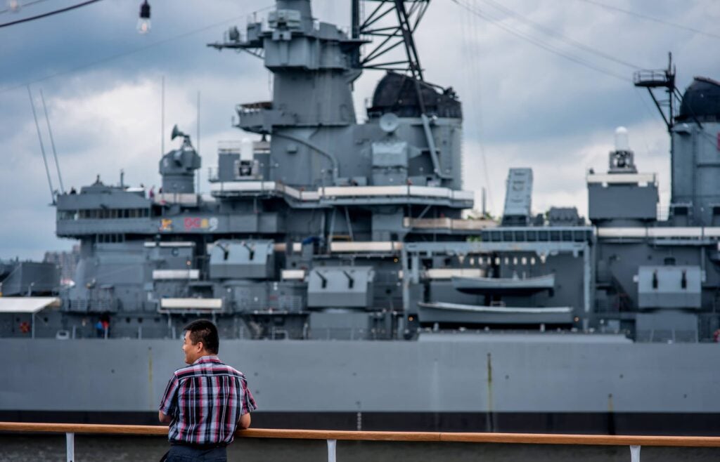 Guest onboard City Cruises overlooking military ship in Philadelphia