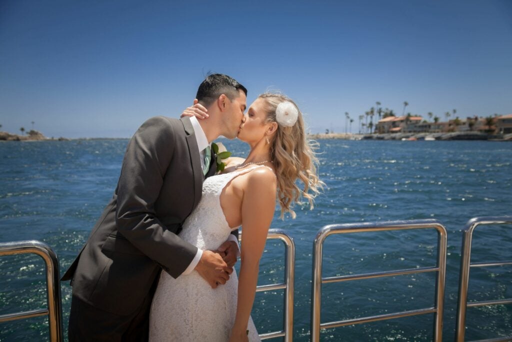 bride and groom kissing on boat in sandiego