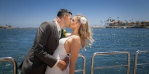 bride and groom kissing on boat in sandiego